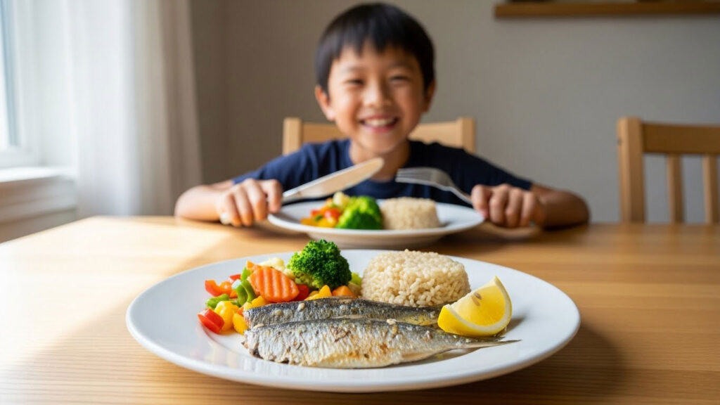 Hidangan ikan berlemak bersama nasi dan sayur di meja makan dengan anak bersedia menjamu selera.