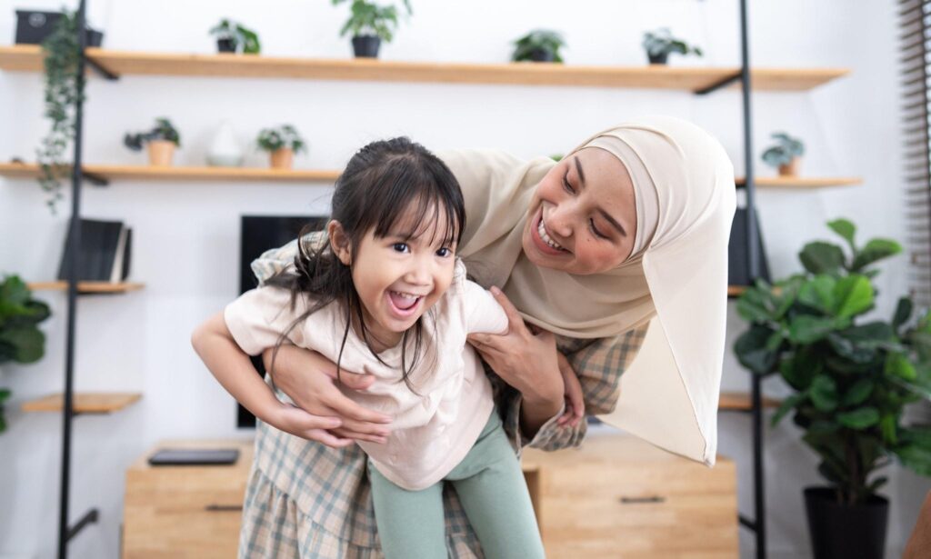 Ibu dan anak Melayu melakonkan semula watak dalam cerita rakyat menggunakan prop ringkas.